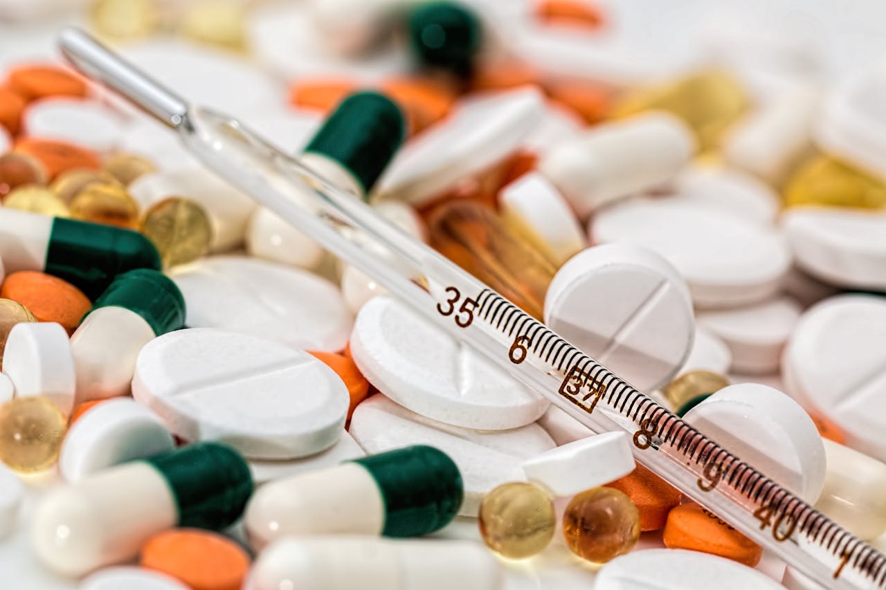 services-04 Close-up image showing various pills and a thermometer, emphasizing health and medicine.